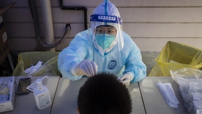 A worker in personal protective equipment collects a swab sample for a round of Covid-19 testing. (Representational image) (Bloomberg)