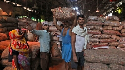 A labourer carries a sack of onions at a wholesale market in Kolkata. (REUTERS)
