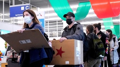 Travelers line up wearing protective masks indoors at O'Hare International Airport in Chicago. (AP)