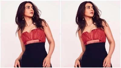 Rakul Preet paired a corset style red top striped in yellow and slip-in details with a pair of black high-waisted trousers lined with black leather at the sides and consisting of wide legs. (Instagram/@rakulpreet)