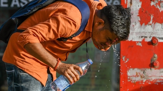 A man takes respite from the heatwave by washing his face with water on a summer day, in New Delhi.(HT Photo)