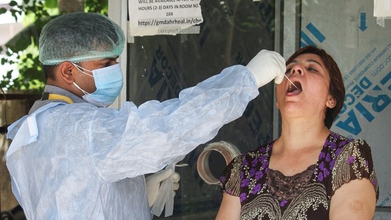 A healthworker collects swab samples of residents for Covid-19 testing, in Gurugram.(PTI)