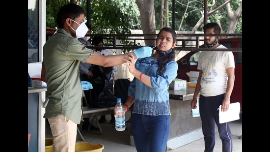 A healthcare worker collects the swab sample of a woman for Covid-19 testing, in Gurugram on Monday. (ANI)