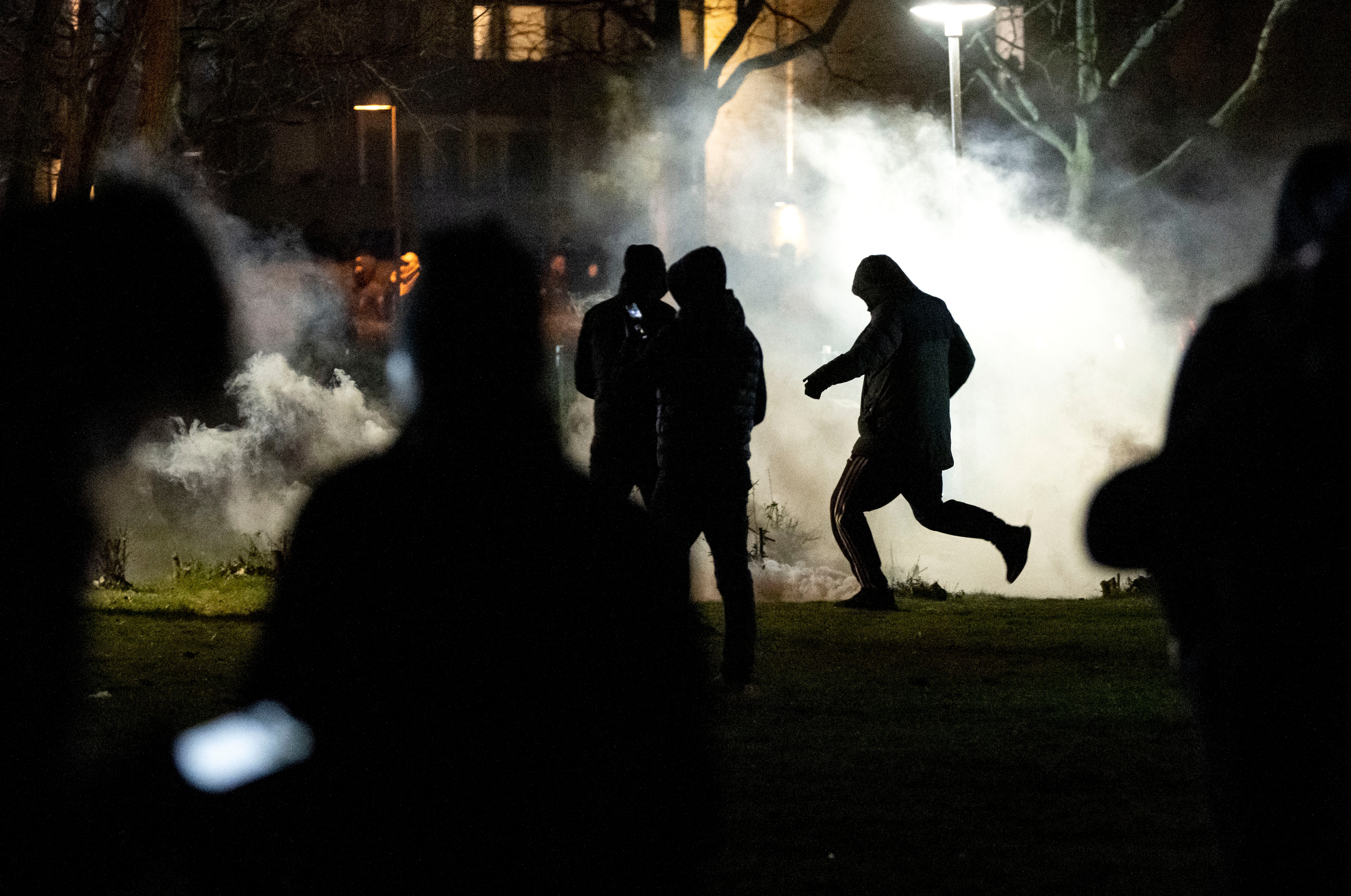 People are silhouetted by smoke after protests broke out at Rosengard in Malmo on April 17, 2022.&nbsp;(via AP)