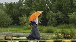 A girl walks with her umbrella in rain that lashed Srinagar on Tuesday. (PTI)