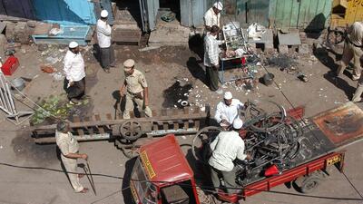 Local residents and police personnel clear debris at a blast site in Malegaon. Reuters File Photo