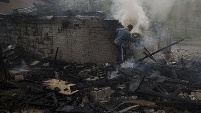 A man tries to extinguish a fire following a Russian bombardment at a residential neighborhood in Kharkiv, Ukraine, on Tuesday. (AP) A man tries to extinguish a fire following a Russian bombardment at a residential neighborhood in Kharkiv, Ukraine, on Tuesday. (AP)