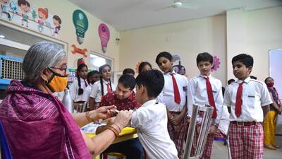 A healthcare worker administers a dose of the Covid-19 preventive vaccine to a student in the age group of 12 to 14 years, at a school in Bikaner on Tuesday. (PTI) A healthcare worker administers a dose of the Covid-19 preventive vaccine to a student in the age group of 12 to 14 years, at a school in Bikaner on Tuesday. (PTI)