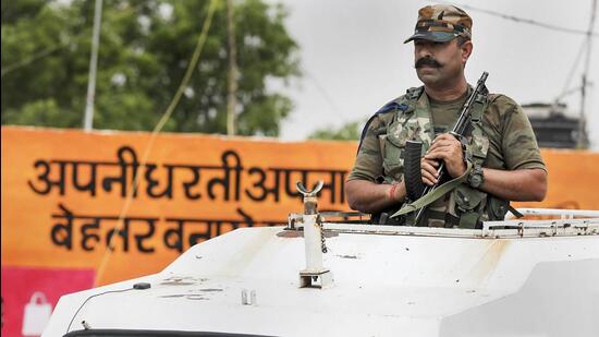 A special operations group officer of the Jammu and Kashmir Police keeps vigil ahead of Prime Minister Narendra Modi's upcoming visit, at Palli panchayat in Samba district, on Tuesday. (PTI)