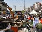 A bulldozer demolishes an illegal structure during an anti-encroachment drive in Jahangirpuri, New Delhi, on April 20, 2022. Several structures in Jahangirpuri were brought down amid heavy paramilitary and police presence during the North Delhi Municipal Corporation’s anti-encroachment drive that was stopped within hours following a Supreme Court order.(Amal KS / HT Photo)