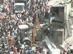 A bulldozer can be seen taking down what appear to be roadside food stalls and shops.