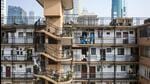 Quarantine workers in personal protective equipment (PPE) at a residential building during a lockdown due to Covid-19 in Shanghai, China, on Wednesday. (Bloomberg) Quarantine workers in personal protective equipment (PPE) at a residential building during a lockdown due to Covid-19 in Shanghai, China, on Wednesday. (Bloomberg)