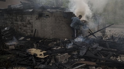 A man tries to extinguish a fire following a Russian bombardment at a residential neighborhood in Kharkiv, Ukraine (AP) A man tries to extinguish a fire following a Russian bombardment at a residential neighborhood in Kharkiv, Ukraine (AP)