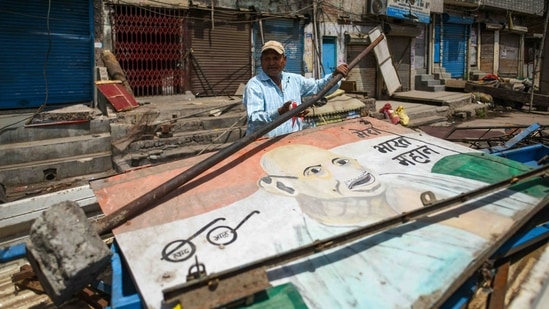 A North Delhi Municipal Corporation worker loads the debris onto a cycle cart during the anti-encroachment drive in Jahangirpuri, New Delhi, on April 20, 2022. Before the anti-encroachment drive was stopped, the civic body had bulldozed a number of temporary shops and structures, PTI reported.(Amal KS / HT Photo)