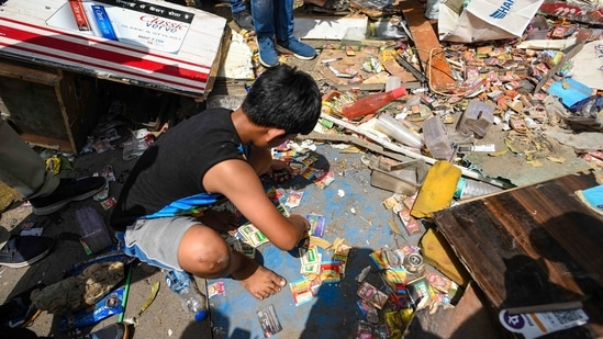 Asif, 12, weeds through whatever was left of his parents' cold drink kiosk at the Kushal Cinema junction after it was demolished in Jahangirpuri, New Delhi, on April 20, 2022. This was the first kiosk which was demolished by the authorities, HT reported.(Amal KS / HT Photo)