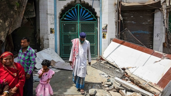 A man walks amid the rubbles of the front gate of a mosque after it was demolished in Jahangirpuri, New Delhi, on April 20, 2022. (Amal KS / HT Photo)