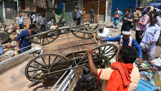 North Delhi Municipal Corporation workers during the anti-encroachment drive in Jahangirpuri, New Delhi, on April 20, 2022. A Supreme Court bench headed by Chief Justice N V Ramana ordered a status quo and agreed to hear a petition challenging the action of the civic bodies allegedly aimed against those involved in April 16 communal clashes, PTI reported.(Amal KS / HT Photo)