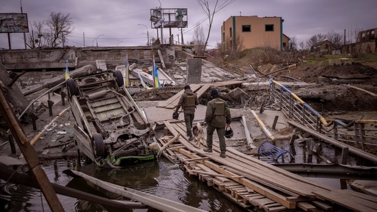 Ukrainian soldiers walk on a destroyed bridge in Irpin, on the outskirts of Kyiv.