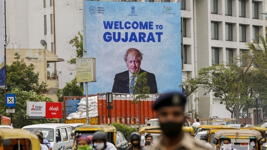 Traffic moves past a hoarding placed in Ahmedabad for the welcome of UK Prime Minister Boris Johnson ahead of his visit to India.(PTI)