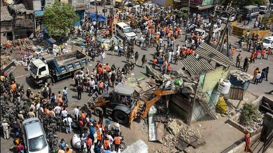 An aerial view of a bulldozer demolishing an illegal structure during an anti-encroachment drive by North Delhi Municipal Corporation, in Jahangirpuri, New Delhi, on Wednesday, April 20, 2022. (Amal KS/HT Photo)