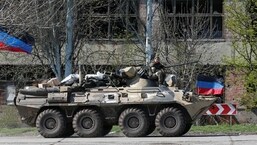 A service member of pro-Russian troops is seen on an armoured personnel carrier as evacuees board buses to leave the city during Ukraine-Russia conflict in the southern port of Mariupol, Ukraine.
