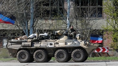A service member of pro-Russian troops is seen on an armoured personnel carrier as evacuees board buses to leave the city during Ukraine-Russia conflict in the southern port of Mariupol, Ukraine. (REUTERS)