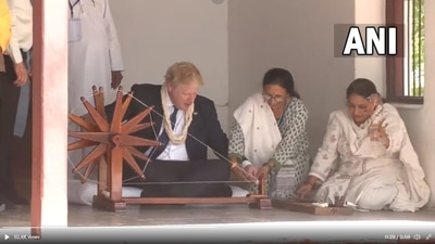 UK Prime Minister Boris Johnson tries his hand on the ‘charkha’ at Sabarmati Ashram in Ahmedabad, Gujarat. (ANI)