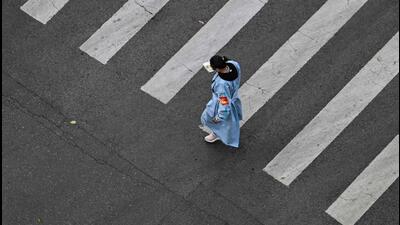 A worker wearing protective clothes walks along a street during a Covid-19 coronavirus lockdown in the Jing'an district in Shanghai on Thursday. (AFP) A worker wearing protective clothes walks along a street during a Covid-19 coronavirus lockdown in the Jing'an district in Shanghai on Thursday. (AFP)