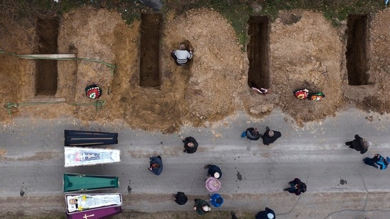 The bodies of four people who died during the Russian occupation await burial during funerals in Bucha, on the outskirts of Kyiv.(AP)