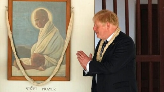 British Prime Minister Boris Johnson pays respect to Mahatma Gandhi during a visit to Gandhi Ashram in Ahmedabad.(AP)