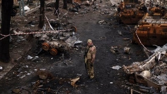 A Ukrainian serviceman stands amid destroyed Russian tanks in Bucha, on the outskirts of Kyiv, Ukraine, (AP)