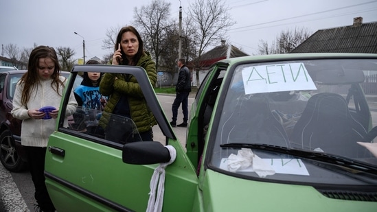 Family fleeing Russian attacks had white ribbons tied on their car. (Photo by Ed JONES / AFP)