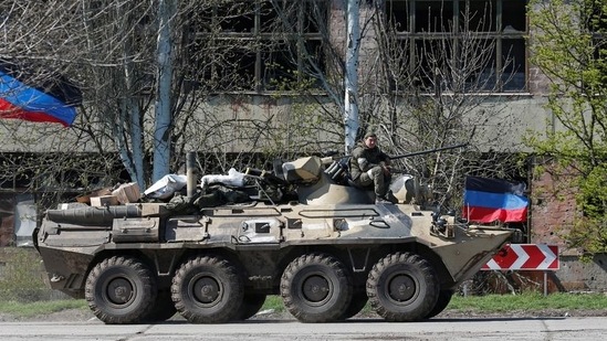 A service member of pro-Russian troops is seen on an armoured personnel carrier as evacuees board buses to leave the city during Ukraine-Russia conflict in the southern port of Mariupol, Ukraine.(REUTERS)