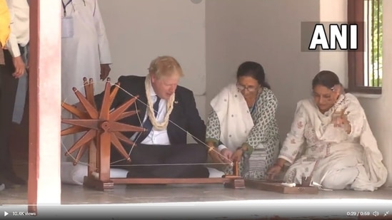 UK Prime Minister Boris Johnson tries his hand on the ‘charkha’ at Sabarmati Ashram in Ahmedabad, Gujarat.(ANI)