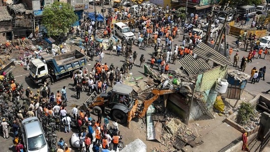 An aerial view of a bulldozer demolishing an illegal structure during an anti-encroachment drive by North Delhi Municipal Corporation, in Jahangirpuri, New Delhi, on Wednesday. (Amal KS/HT Photo)