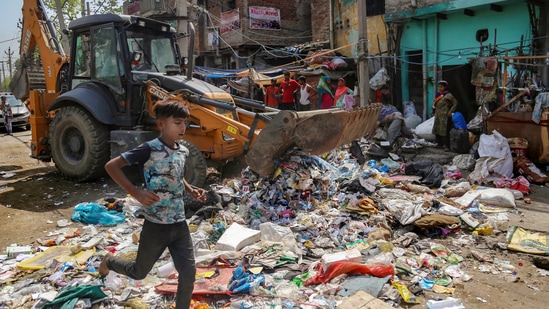 A woman resident reacts during a joint anti-encroachment drive by NDMC, PWD, local bodies and the police, in the violence-hit Jahangirpuri area, in New Delhi, Wednesday, April 20, 2022. (PTI Photo)