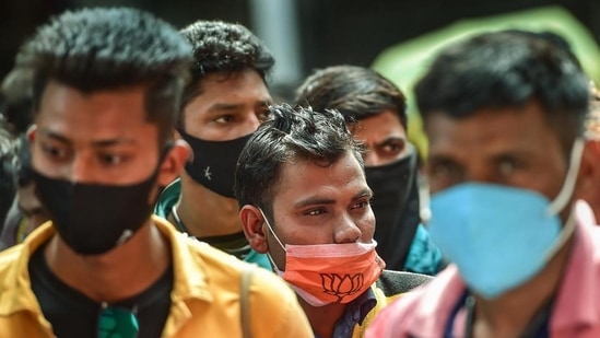 Passengers wearing face masks stand in a queue for Covid-19 test at Krantiveer Sangoli Rayanna railway station in Bengaluru (PTI)