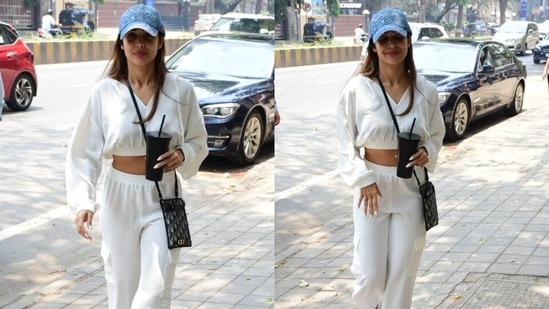 On Thursday, paparazzi clicked Malaika out and about on the Mumbai streets. They clicked the diva smiling and waving at the cameras. She looked stunning in a breezy all-white cropped sweatshirt and joggers set that deserve a special place in your summer essentials mood board.(HT Photo/Varinder Chawla)