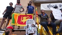 Um manifestante do Sri Lanka usa uma máscara facial condenando os ataques do domingo de Páscoa de 2019, protestos contra a crise econômica do lado de fora do escritório do presidente em Colombo, Sri Lanka, quinta-feira, 21 de abril de 2022. (AP Photo/Eranga Jayawardena)