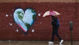 Um homem passa por um mural na véspera do Dia da Terra, na Filadélfia.  (Matt Rourke/AP)