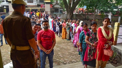 Guwahati: Security personnel keep vigil as voters wait in a queue to cast their votes for the Guwahati Municipal Election 2022, at Rupnagar in Guwahati, Friday, (PTI) Guwahati: Security personnel keep vigil as voters wait in a queue to cast their votes for the Guwahati Municipal Election 2022, at Rupnagar in Guwahati, Friday, (PTI)