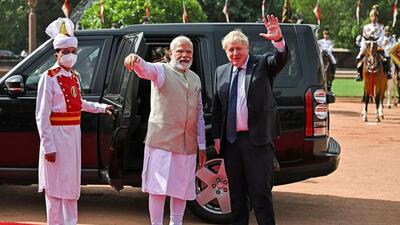 British Prime Minister Boris Johnson waves as his Indian counterpart Narendra Modi watches after a ceremonial reception at India's presidential palace Rashtrapati Bhavan, in New Delhi on Friday, April 22, 2022. (Reuters) British Prime Minister Boris Johnson waves as his Indian counterpart Narendra Modi watches after a ceremonial reception at India's presidential palace Rashtrapati Bhavan, in New Delhi on Friday, April 22, 2022. (Reuters)