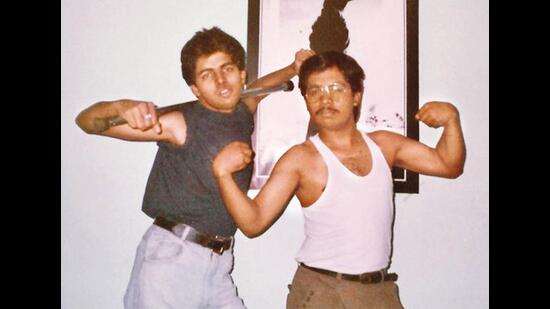 Flexing his muscles with his brother in front of an iconic Michael Jackson poster