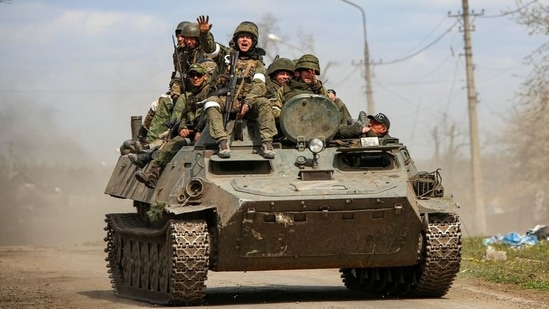 Service members of pro-Russian troops are seen atop of an armoured vehicle during Ukraine-Russia conflict in the southern port city of Mariupol, Ukraine.