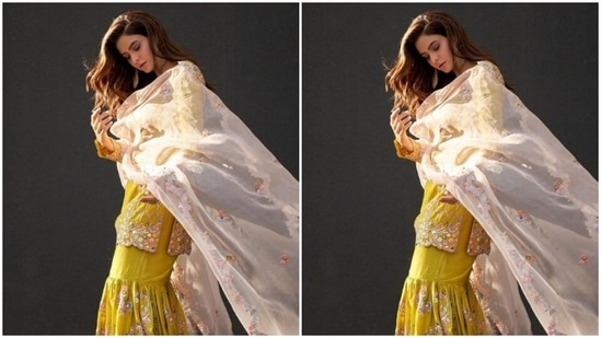 Aamna paired a yellow short full-sleeved kurta intricately decorated in multicolour resham threads with a pair of yellow sharara and a white dupatta with embroidery details and tassels at the corners.(Instagram/@aamnasharifofficial)
