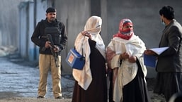पाकिस्तान दो देशों में से एक है - अफगानिस्तान के साथ - जहां पोलियो अभी भी स्थानिक है।  फोटो में- 24 जनवरी, 2022 को खैबर पख्तूनख्वा प्रांत में मर्दन के बाहरी इलाके में घर-घर पोलियो टीकाकरण अभियान के दौरान एक पुलिसकर्मी स्वास्थ्य कर्मियों को ले जाता है।