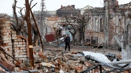 Um homem caminha perto de prédios danificados durante o conflito Ucrânia-Rússia na cidade portuária de Mariupol, no sul da Ucrânia.