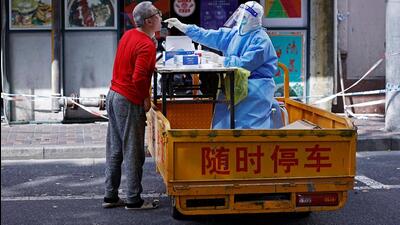 A medical worker in a protective suit collects a swab from a resident for nucleic acid testing, amid the coronavirus disease (Covid-19) outbreak in Shanghai, China. (VIA REUTERS) A medical worker in a protective suit collects a swab from a resident for nucleic acid testing, amid the coronavirus disease (Covid-19) outbreak in Shanghai, China. (VIA REUTERS)