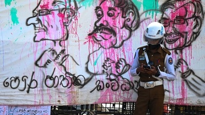 A policeman stands guard in front of a banner during an ongoing anti-government demonstration near the president's office in Colombo. (AFP) A policeman stands guard in front of a banner during an ongoing anti-government demonstration near the president's office in Colombo. (AFP)