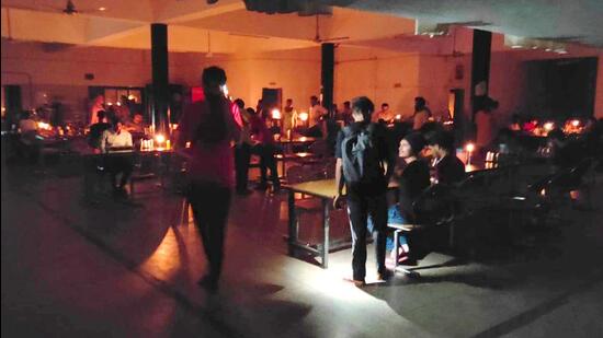 Panjab University’s hostellers eating dinner amid the power outage in Chandigarh on Tuesday night. (HT Photo)
